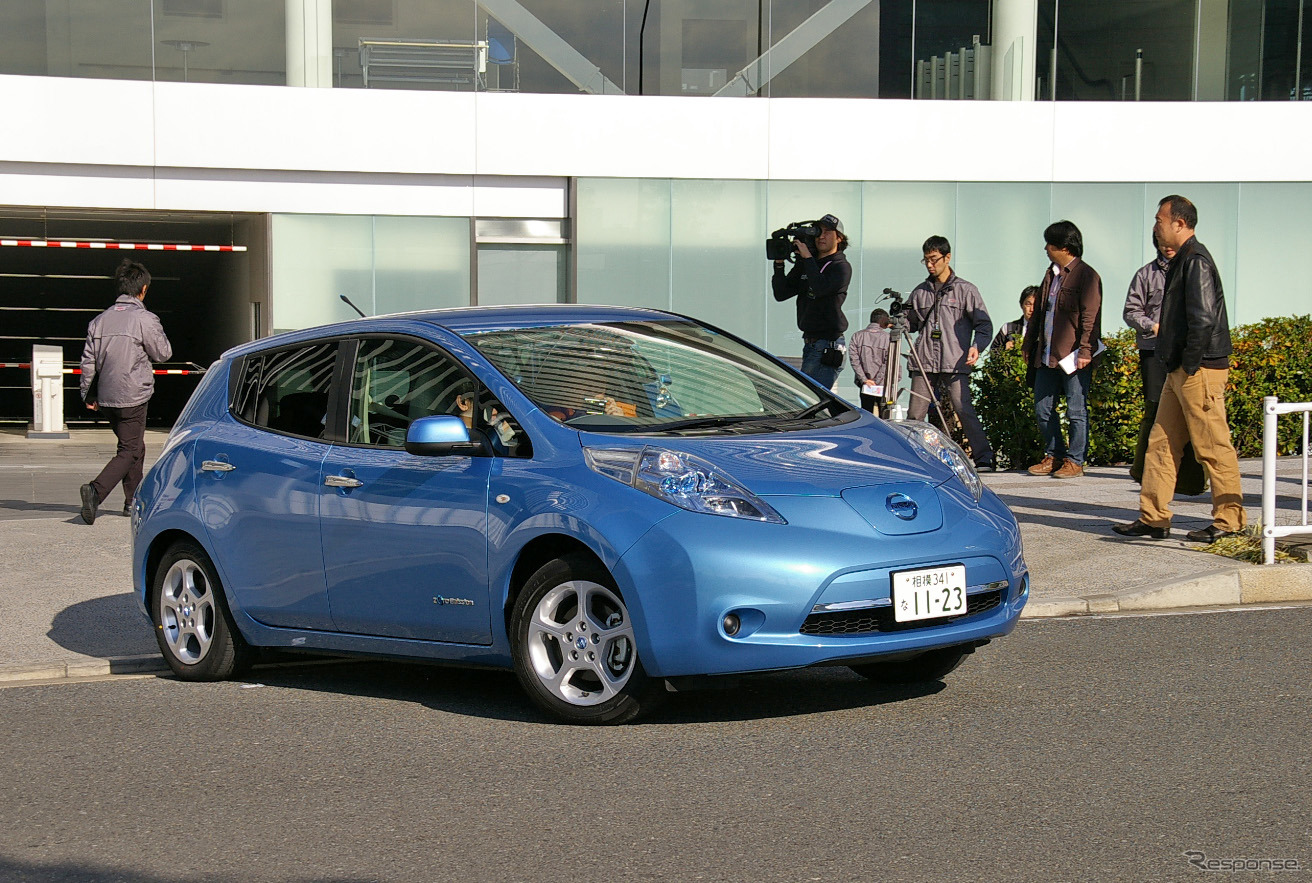 報道陣に見送られ日産本社を出発するリーフ