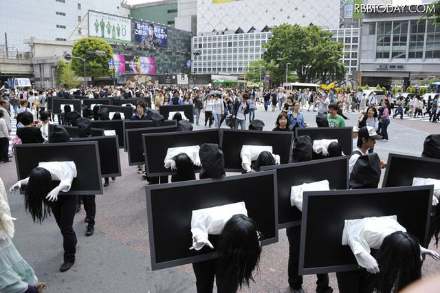 突如渋谷に登場した50人以上の貞子（ＴＶモニターから飛び出した半身の貞子を抱えた黒子姿で）