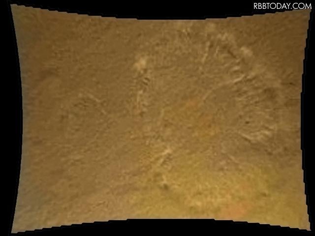 キュリオシティ、火星表面まで約20メートル。地表のほこりがロケット噴射によって丸く巻き上げられている。