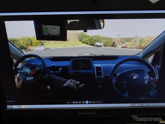 RoboCar PHV運転のデモ映像。運転者がリモコン代わりに操作しているのは、助手席に設置したゲーム機用のハンドル型コントローラー。（参考画像）