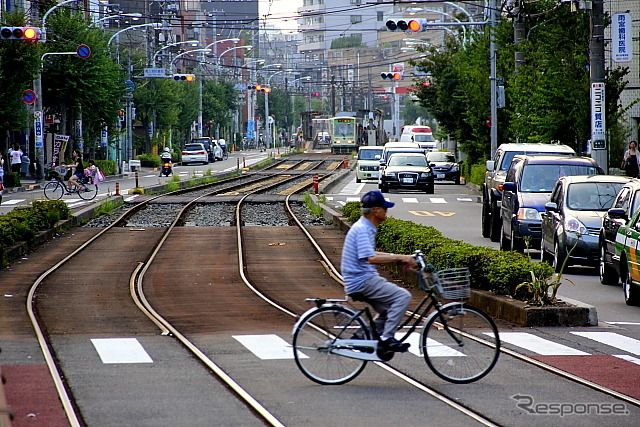 線路の両側に一方通行路の車道が並ぶ熊野前電停付近