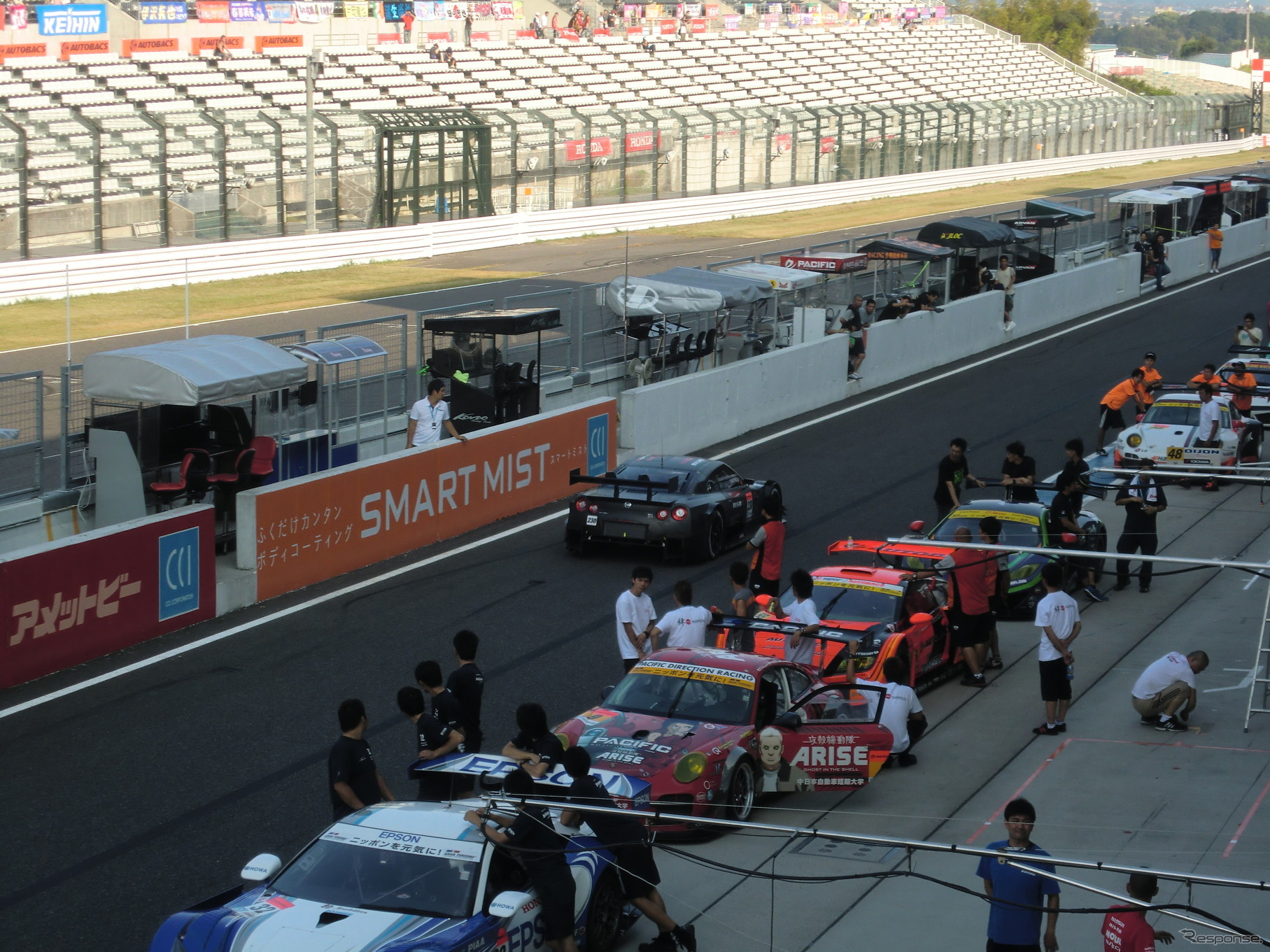 予選前日、現行車両の車検待ち渋滞の横を、14年型GT-Rが通過する。