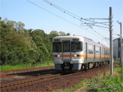 東成岩駅付近を走る武豊線の気動車。既に架線柱の設置と架線の敷設が完了している。