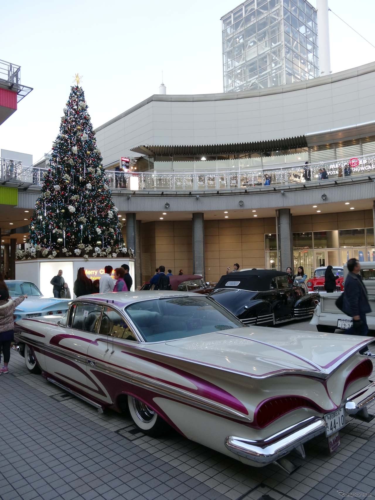 クリスマスイルミと共に華やかななカラーリングのクラシックカーを大量展示
