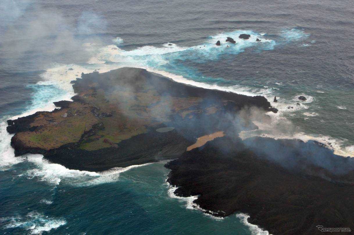 海上保安庁が2013年12月26日に撮影した西之島（左）と新しい島（右）。新しい島の急速な拡大で両島がつながった。