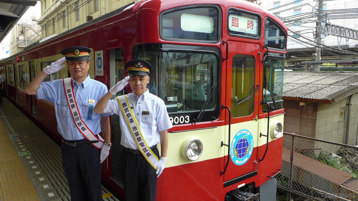 池袋駅で開かれた出発式。「幸運の赤い電車」の前でポーズをとる西武・京急の駅長