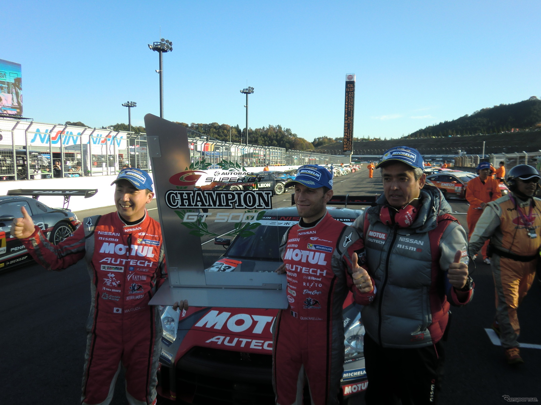チャンピオンボードを掲げる（左から）松田次生、クインタレッリ、鈴木豊監督。