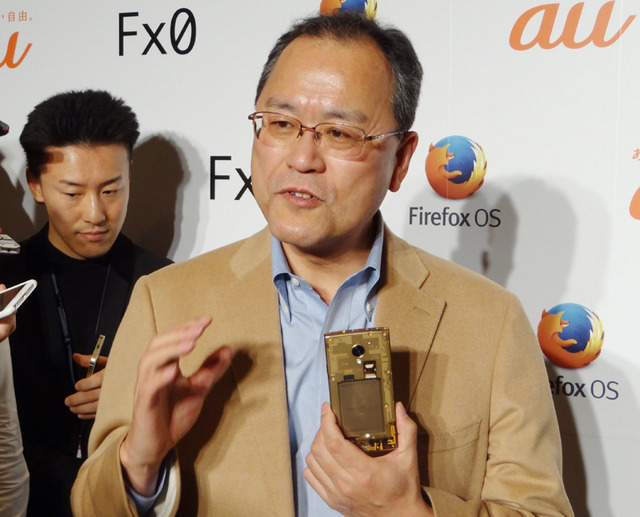 記者の取材に答えるKDDI・田中社長