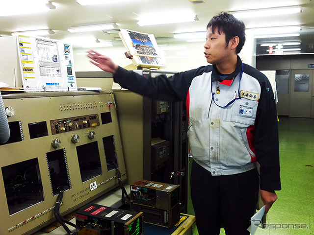 B767に付くFMC（Flight Management Computer）を前に解説するJALエンジニアリング・飛行制御課 の遠藤裕喜さん