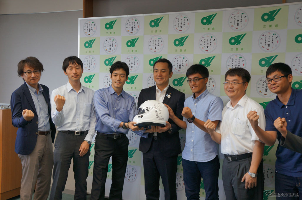 知事からの応援メッセージが書かれたヘルメットとともに記念写真