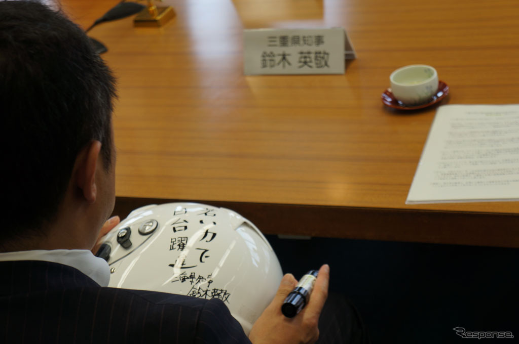 チームのヘルメットに直筆で応援メッセージを書く鈴木知事