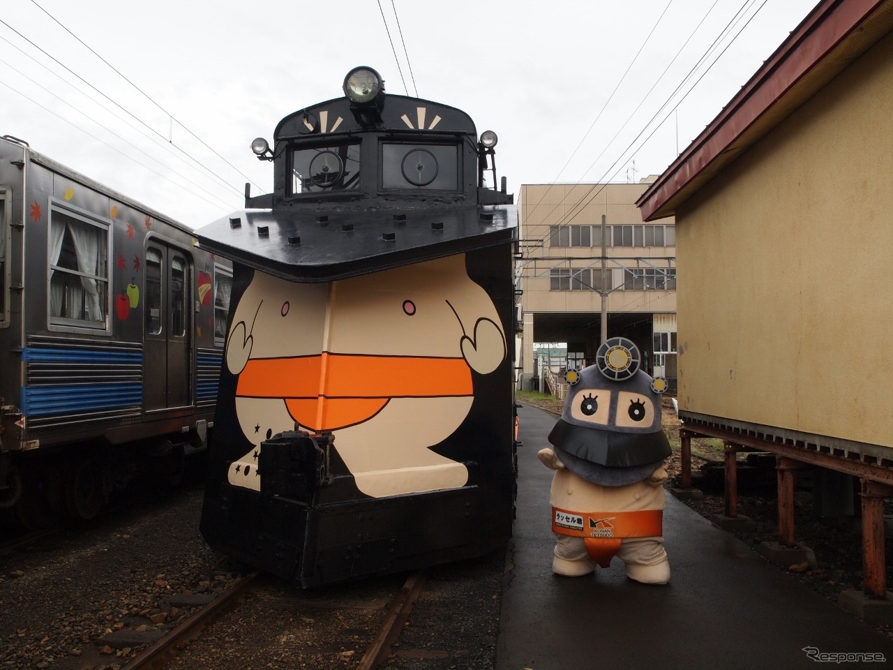 青森県の弘南鉄道でこのほど、子どもたちがラッセル車キ100形にラッピングを施すイベントが開かれた。マスコットキャラクター「ラッセル君」（右）デザインのラッピングを施したキ100形