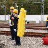 列車からの非常脱出に使うハシゴは駅に常備されており、職員が背負って運ぶ。