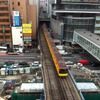 2012年3月、トンネルを出て渋谷駅に進入する電車。写真右上の建物がヒカリエで、線路との間に移設スペースがあるのがわかる。また新しい橋脚が従来の線路の両側に立ち上がっているのも見える。