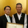 在パキスタン日本国大使館での表彰式、倉井高志 パキスタン大使（左）とスズキ 永尾博文常務