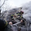 ウクライナ、キエフ市内で、ロシアに攻撃された建物から市民を救出する消防士（3月14日）