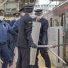 飛田給駅で緊急停車した電車に、警察官と駅員がさすまたや警棒、防護シールドを持って乗り込む。