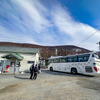 列車と代替バスの中継駅となっている東鹿越駅。奥のキハ40は富良野方面へ折り返す2482D。駅前は道路1本を挟んでかなやま湖の光景が広がる。