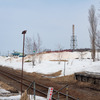 石狩沼田駅の敷地外から見た留萌方の線路。はるか先には車止めが設けられており、まだ数人の係員が作業をしていた。2023年4月4日。