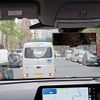 前方の軽バンは左の空いたスペースに路駐したそうだが、自転車が来ているせいか、動きがなかなか定まらない。