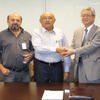 調印後に握手する、東海ゴム工業の尾崎副社長（右）とProduflex MG社の Edgar President（中央）、Expedito氏