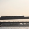 夕日を浴びながら隅田川を渡る日暮里・舎人ライナーの列車。