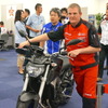 修理のためにバイクを運ぶ選手