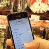 チェックリスト「きょう買うもの」を見ながらショッピングモールを歩く