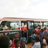 子どもたちに囲まれるチーム移動バス