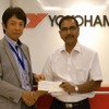 インド赤十字社のピー・シー・パルティハリ副長官（右）に義援金を手渡す藤津聡YIN社長