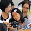 夏休みイベントの醍醐味は、親子で出来事を共有しながら学べること。子ども新聞に利用する写真を一緒に選定する親子のようす　＜撮影：稲葉九＞