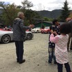 ずっとスマホを話し合ない少女。ずっとあたりにおいてあるあるクルマをくまなくアルバムに収めていた。