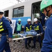 列車内の負傷者は多人数で搬出していく。