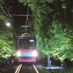 ライトアップされた「もみじのトンネル」を走る叡山電鉄の電車。