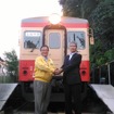 姉妹鉄道協定の締結が決まり、いすみ鉄道キハ52形の前で握手を交わす、いすみ鉄道の鳥塚社長（左）と養老鉄道の都司（つじ）社長（右）。
