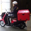 新宿郵便局を出発する『ベンリィ イー』の郵便配達車