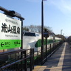 流山温泉駅の駅名標。奥は200系。2002年4月27日。