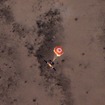 レッドブル「プレーン・スワップ」：パラシュートで降下する無人の機体（4月25日）。