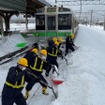 2月6日来の大雪で千歳線平和駅（札幌市厚別区）で立ち往生した721系普通列車の前で懸命に作業を行なう除雪作業員。
