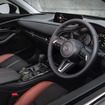 CX-30  インパネのミドルパッドは、ベース車のBlack Tone Edition が黒い合成皮革なのに対して、Retro Sports Edition はシートのメイン材と同じスエード調人工皮革。その下の金属調加飾もサテンクロームからガンメタに変更している  加飾のトーンを下げることで、室内全体のテラコッタ＆ブラックのコントラストを際立たせているのだ