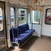 全幅を変えず4人掛けが3人掛けになった車端部シート。優先席ではつかみ棒の位置も変わっている