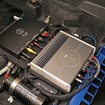 シートを外して助手席の下を見ると、この通りの状態。パワーアンプの脇にはM&Mデザインのキャパシターなども設置されている。