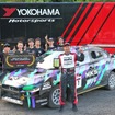 参戦車両とチームメイトの前で表彰盾を掲げる田口勝彦選手