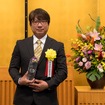 記念トロフィーを受け取る本田技研工業株式会社 四輪開発本部のエグゼクティブチーフエンジニアの滑川健一氏