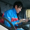 スマートフォンでATMTCアプリを操作するトラックドライバー