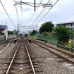 画面奥が秋津駅、鉄橋の下が武蔵野線で、新秋津駅は右側すぐ（踏切から撮影）