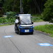 市道を走る「奥永源寺けい流カー」。道路上の黒い線が自動運転を制御するために敷設された電磁誘導線