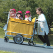 複数の子供が乗っていているカートを、坂道でも楽に操作できる「電動アシストお散歩カー」