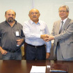 調印後に握手する、東海ゴム工業の尾崎副社長（右）とProduflex MG社の Edgar President（中央）、Expedito氏