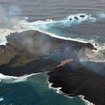 海上保安庁が2013年12月26日に撮影した西之島（左）と新しい島（右）。新しい島の急速な拡大で両島がつながった。